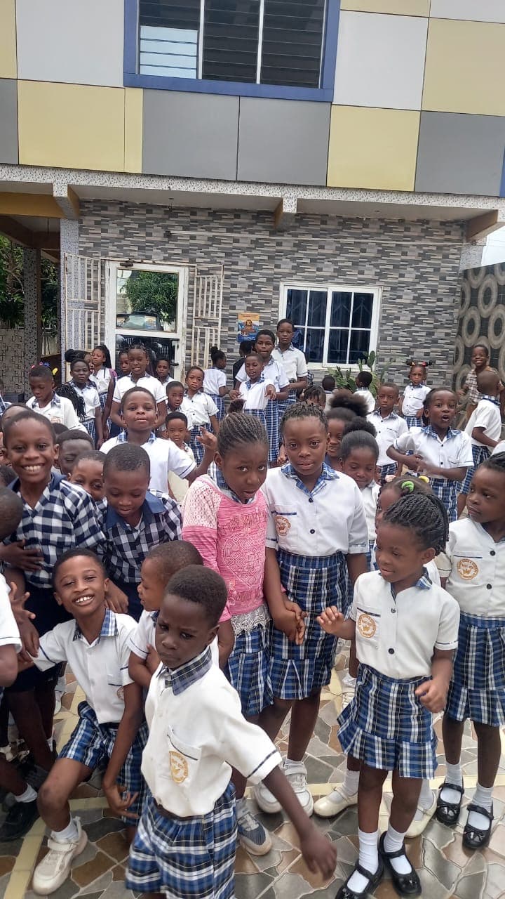 Students in front of the Brainy Kings and Queens school building